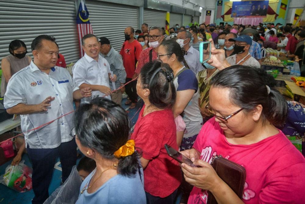 Alexander Nanta Linggi (kiri) menyantuni orang ramai selepas melancarkan program Jualan Murah Keluarga Malaysia di Kampung Bunan, pada Ahad. - Foto Bernama