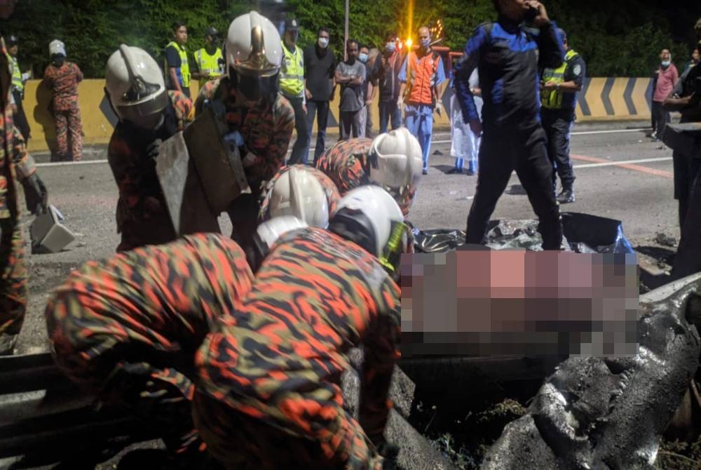 Anggota bomba menjalankan operasi mengeluarkan mangsa yang tersepit pada penghadang jalan. - Foto ihsan Bomba Perak