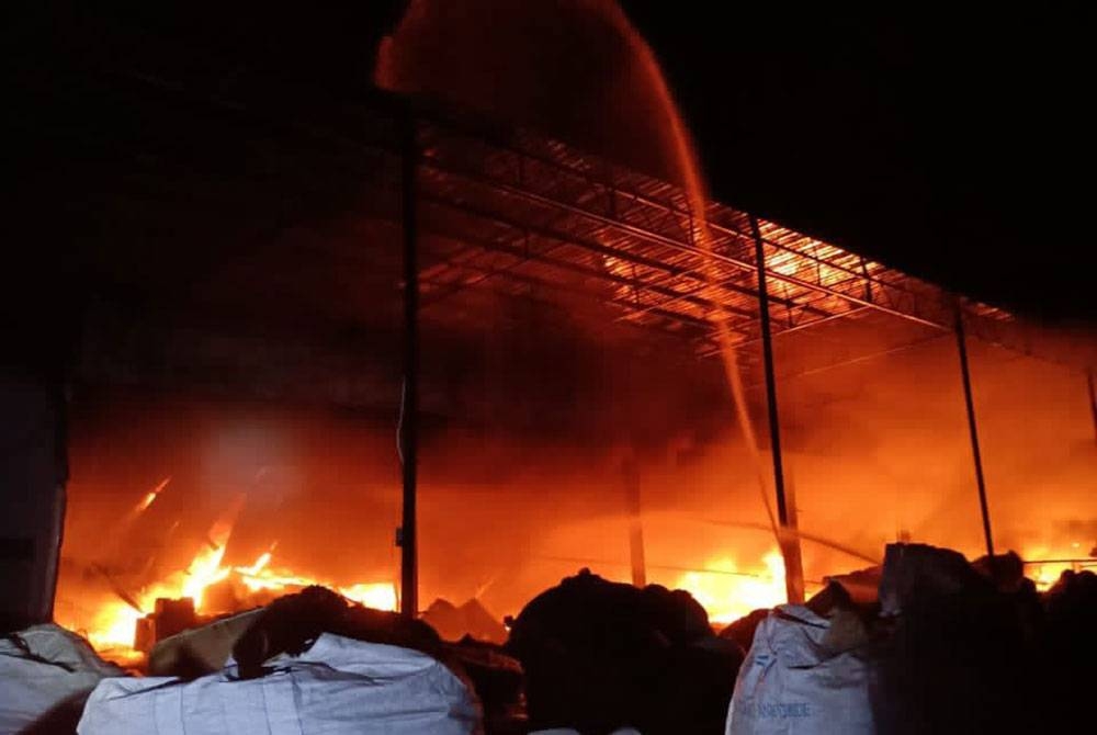 Pasukan bomba memadam api yang sedang marak dalam kebakaran sebuah kilang memproses bahan kitar semula di Permatang Tinggi, Bukit Mertajam.