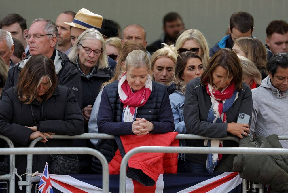 Orang ramai bertafakur selama dua minit semasa menghadiri upacara pengebumian Ratu Elizabeth II di London. - AFP