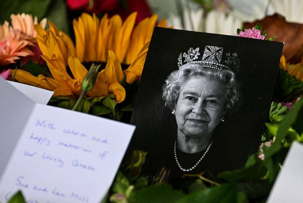 Sebuah potrait Ratu Elizabeth II yang diberi penghormatan orang ramai di Green Park, London. - AFP