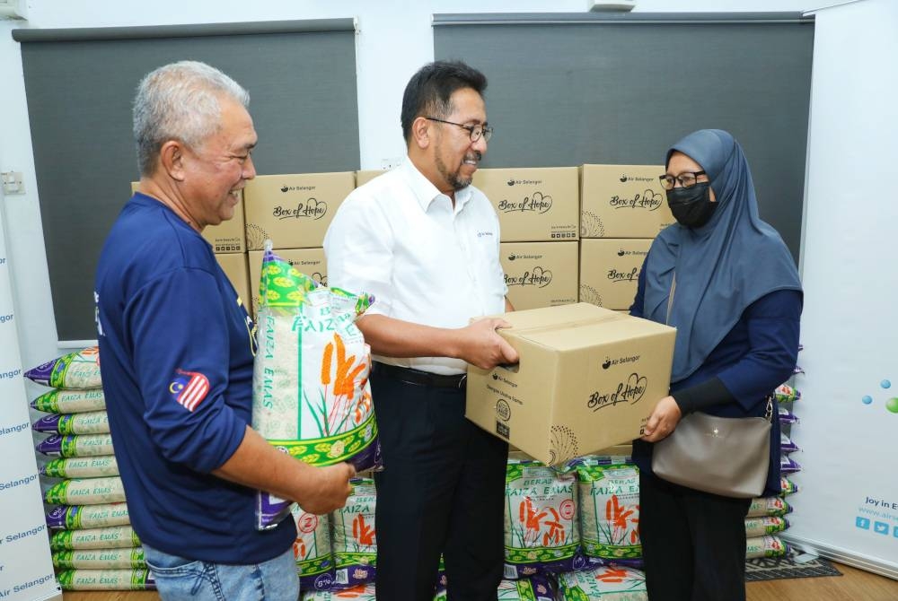 Abas (tengah) menyampaikan sumbangan Box of Hope kepada salah seorang penerima yang tinggal di Pangsapuri Rimba Jaya, Shah Alam, baru-baru ini.