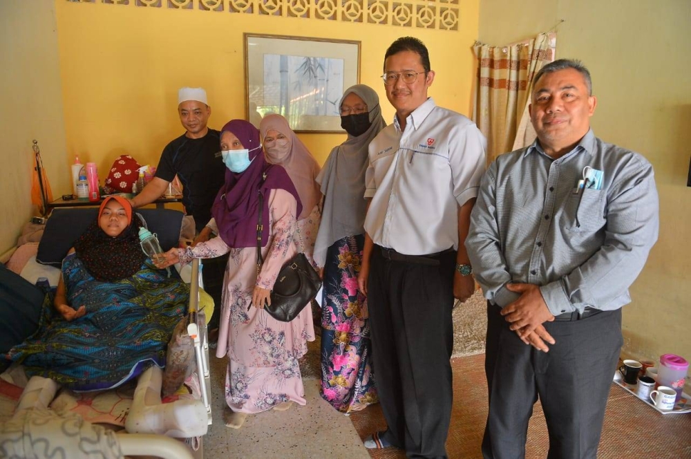 Mohammad Nor Aziz (dua kanan) bersama sekumpulan tiga guru dari SMK Seksyen 16 Shah Alam ketika melawat Nur Jannah di kediaman keluarga pelajar terbabit di Klang.