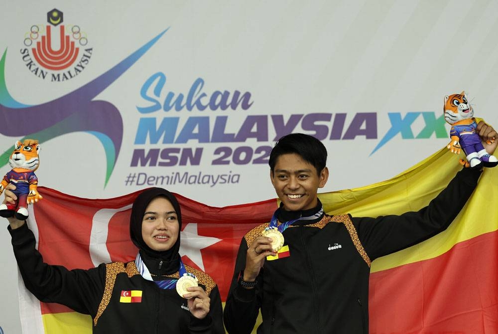 Haiqal Azami (kanan) dan Nurshafila Omar (kiri) bergambar bersama pingat emas dimenanginya dalam acara boling padang kategori pairs campuran akhir pada Sukma di Kompleks Sukan Bukit Kiara pada Selasa. - Foto: Bernama