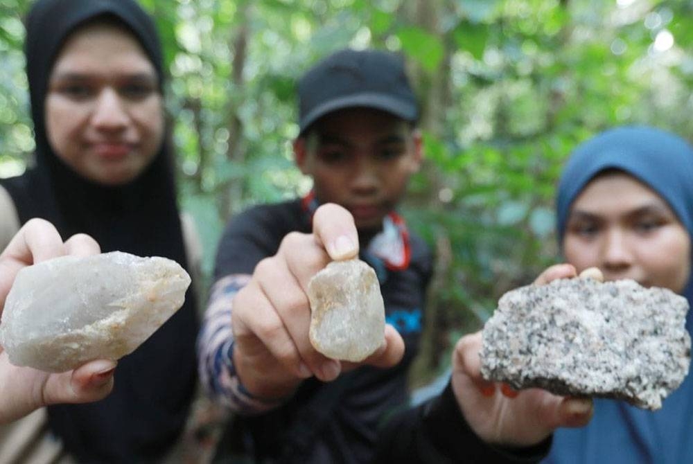 Tiga penuntut UMK menunjukkan batu kristal yang ditemui di Hutan Simpan Jerantut (Tambahan) Ulu Cheka.