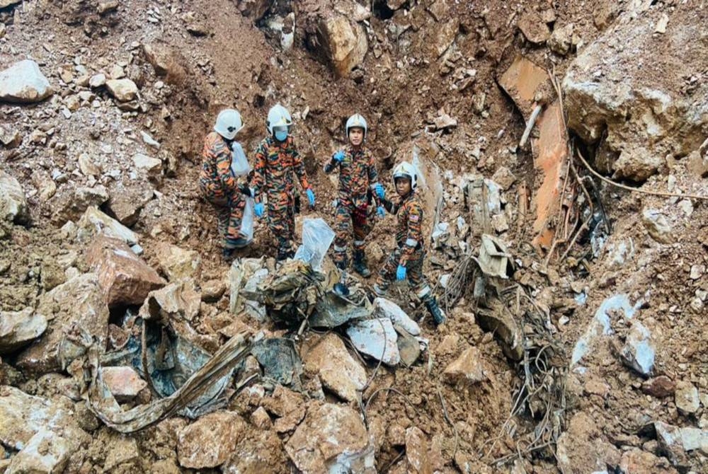 Sebahagian cebisan tulang dipercayai milik mangsa kedua dibawa keluar dari lokasi runtuhan. - Foto Bomba Perak