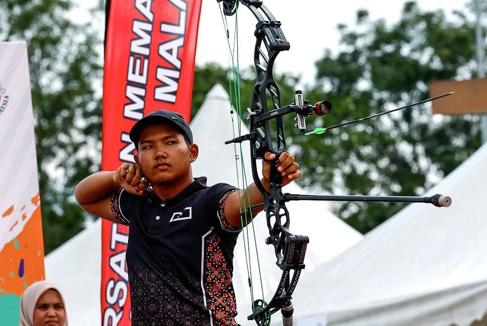 Muhammad Hazmi melakukan panahan ketika menentang Muhammad Ammardalam acara akhir compound individu (pusingan olimpik) lelaki pada Sukma MSN 2022 di Stadium USIM pada Rabu.