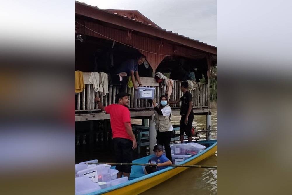 Pasukan sukarelawan banjir menghantar makanan ke rumah mangsa pada 2014.