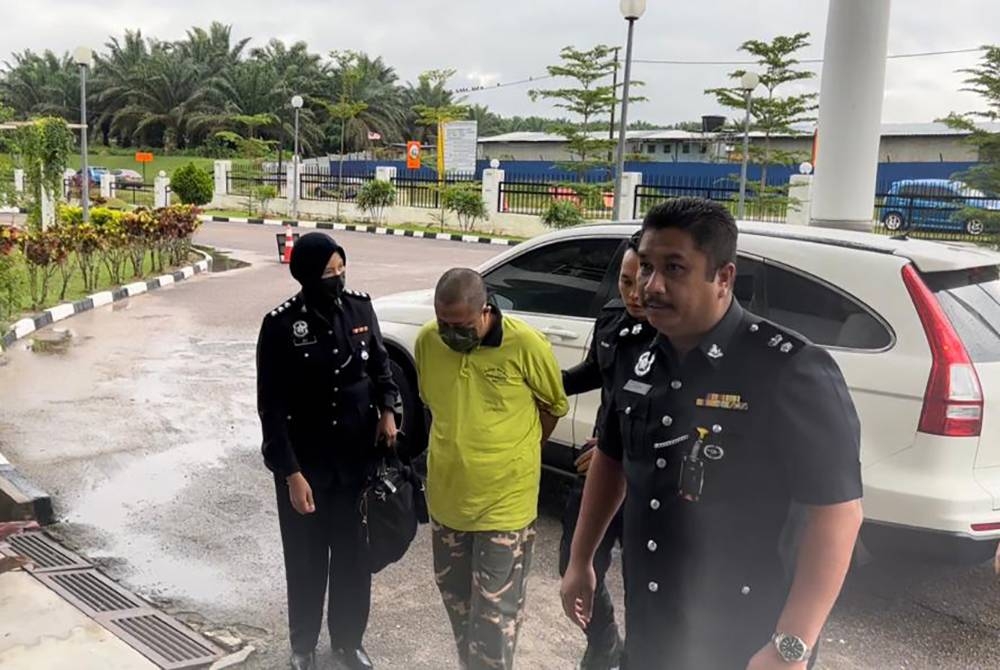 Mohd Nizam (tengah) ketika dibawa ke Mahkamah Sesyen Kota Tinggi pada Khamis.