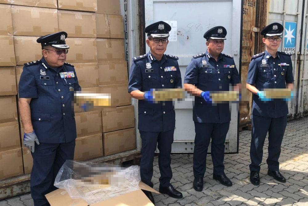 Yu Min (dua dari kiri) menunjukkan rokok yang dirampas di Pelabuhan Sepanggar, Kota Kinabalu.