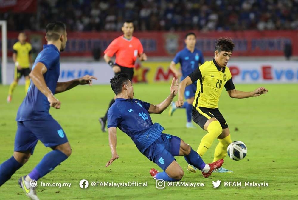 Syafiq Ahmad diasak pemain Thailand semasa perlawanan Piala Raja Thailand 2022 di Stadium 700th Anniversary of Chiang Mai pada Khamis. - Foto FAM