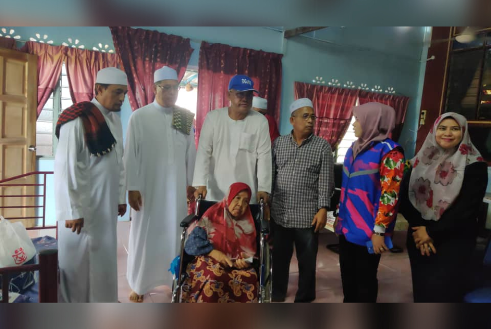 Noh (tiga, kiri) menziarahi salah seorang penduduk dalam program tinjauan mesra (walkabout) di Kampung Sawah Sempadan, pada Jumaat.