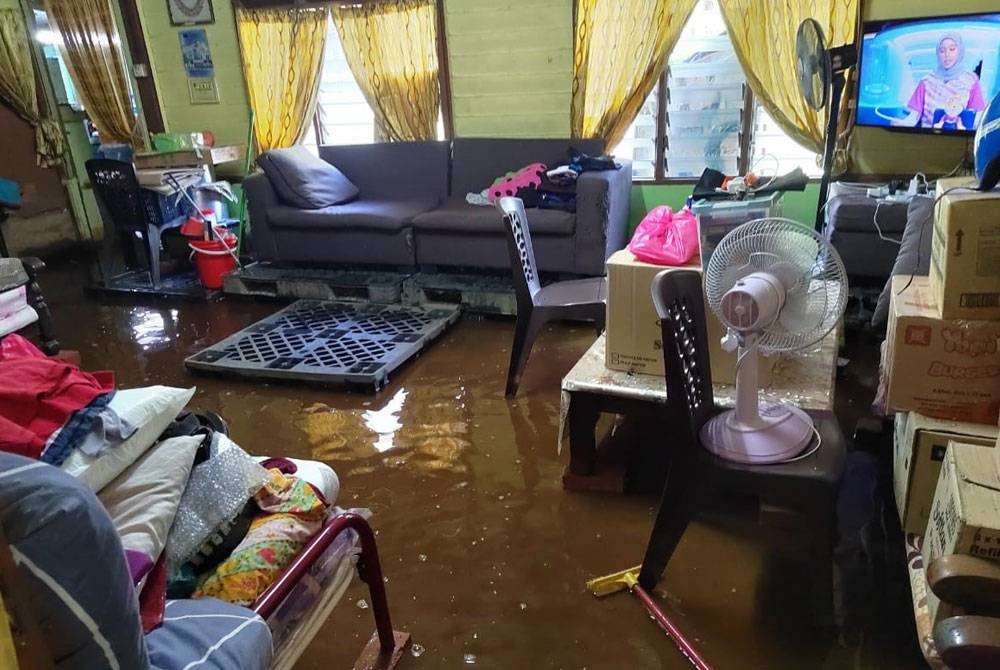 Keadaan rumah penduduk yang masih digenangi banjir termenung.