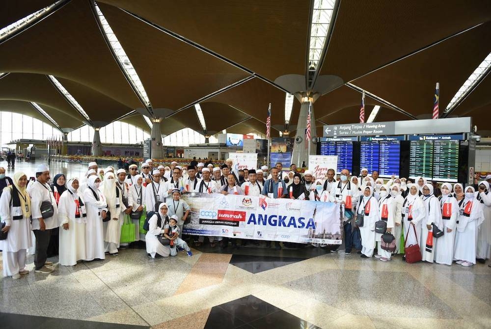 Abdul Fattah (tengah) bersama para jemaah umrah semasa Majlis Flag Off peserta CoopUmrah di Lapangan Terbang Antarabangsa Kuala Lumpur (KLIA) pada Sabtu.