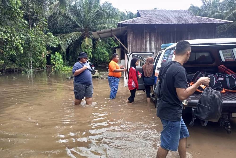 Anggota APM membantu memindahkan mangsa banjir di Kampung Sri Bengkal dan Kampung Bintang Peserai, Batu Pahat, pada Ahad.