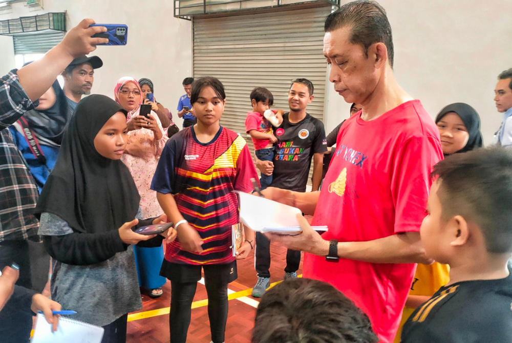 Misbun (tengah) ketika bertemu peserta Kem Bakat Badminton selepas Perasmian dan Penutupan Kem Bakat Badminton Zon Selatan di Krubong pada Ahad.