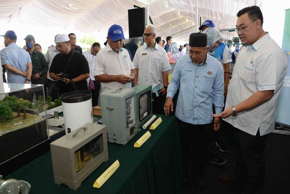 Tuan Ibrahim (dua dari kanan) diberi penerangan mengenai peralatan sukatan lama yang digunakan JPS pada Majlis Sambutan 90 Tahun JPS dan Hari Sungai Sedunia pada Ahad. - Foto Bernama