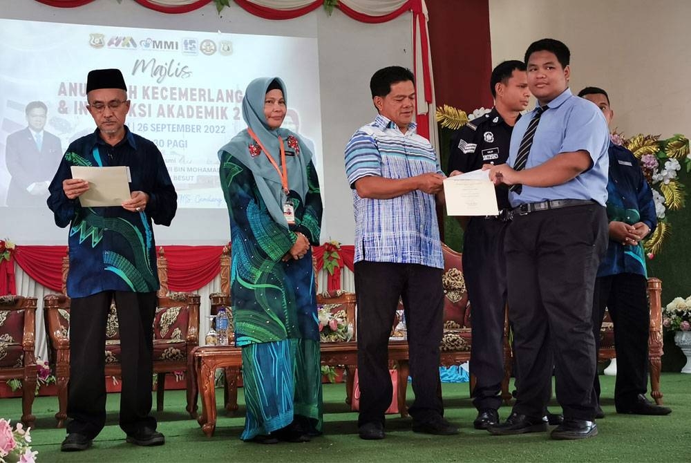 Nathrah (dua dari kiri) bersama Nawi (tiga dari kiri) ketika menyampaikan anugerah kepada pelajar sempena Majlis Anugerah Kecemerlangan dan Interaksi Akademik SMK Tengku Mahmud di Besut pada Isnin.