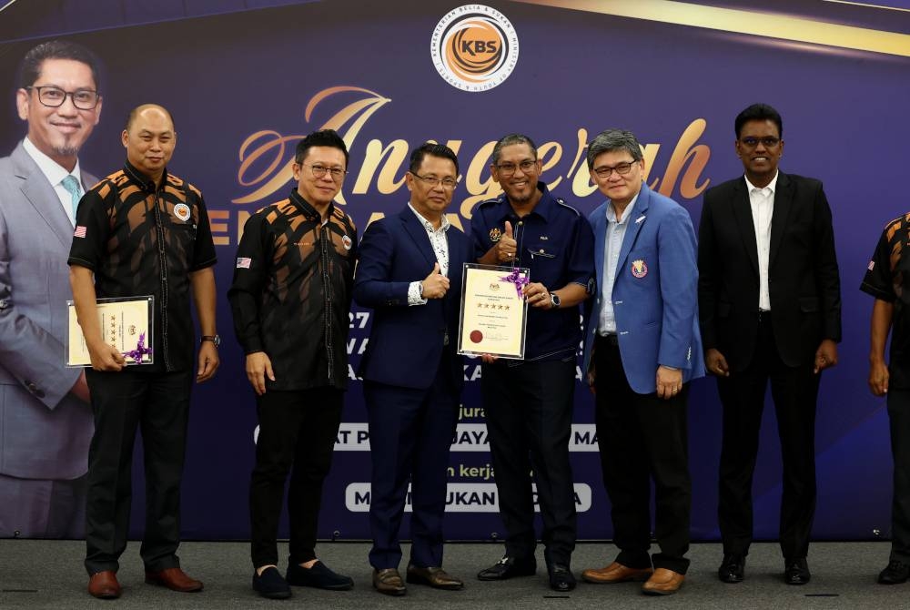 Ahmad Faizal bersama Presiden Persatuan Badminton Malaysia (BAM) Tan Sri Mohamad Norza Zakaria (tiga, kiri) yang menerima Anugerah Penarafan Bintang Badan Sukan 2021 di MSN pada Selasa. - Foto Bernama