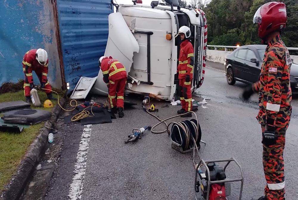 Anggota bomba mengeluarkan mangsa yang tersepit. - Foto ihsan Jabatan Bomba dan Penyelamat