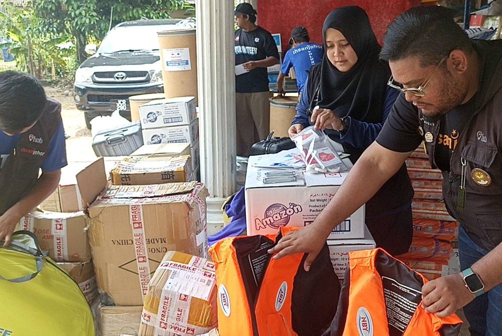 Farrah Faridah (kanan) bersama sukarelawan lain menyusun barangan yang dikumpul Ihsan Johor sebagai persediaan berdepan musim tengkujuh.