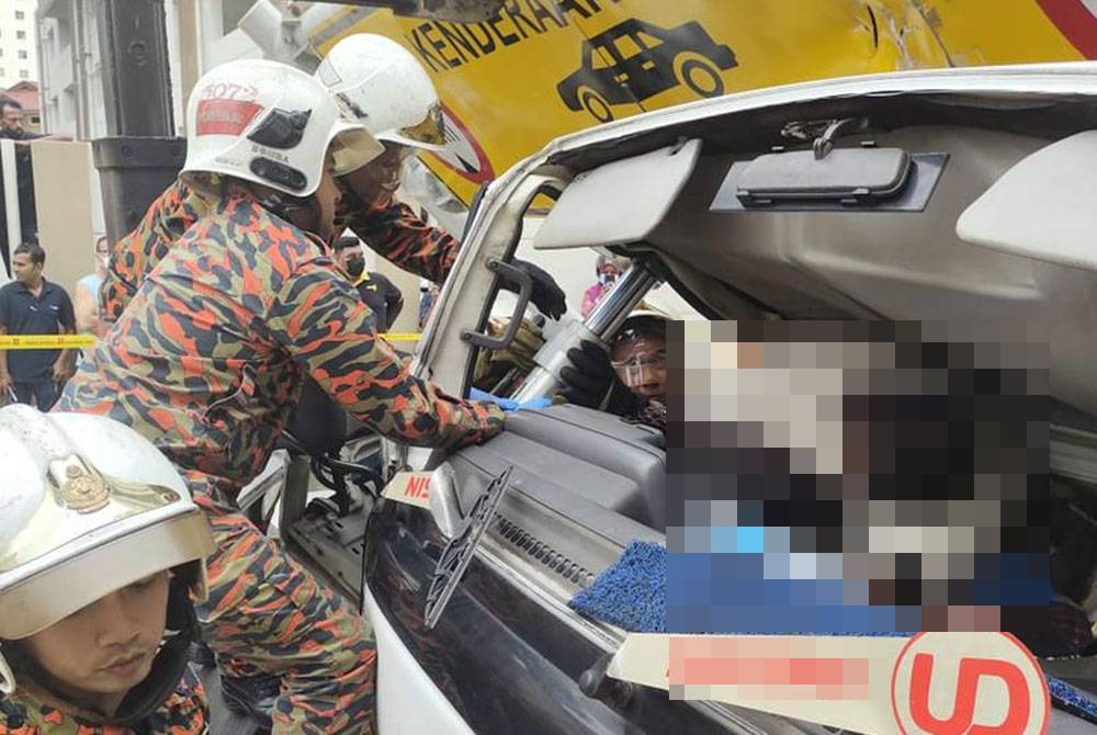 Anggota bomba sedang mengeluarkan mangsa yang tersepit.