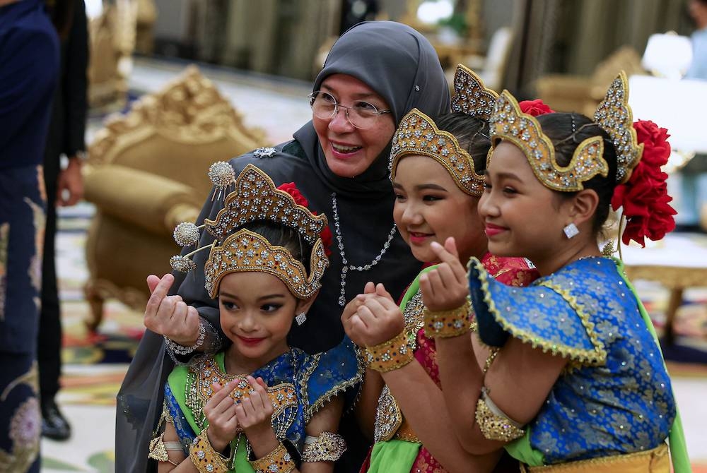 Raja Permaisuri Agong Tunku Hajah Azizah Aminah Maimunah Iskandariah berkenan beramah mesra bersama kanak-kanak yang memperagakan fesyen busana tradisional termasuk songket dan tenun Pahang selepas Majlis Santapan Malam sempena Simposium Tekstil Tradisional ASEAN Ke-8 di Istana Negara pada Khamis. - Foto Bernama