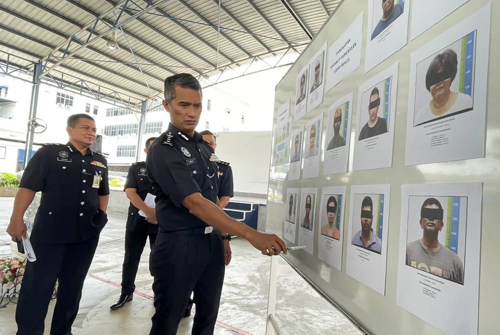 Mohd Shuhaily menunjukkan gambar suspek yang ditahan pada sidang akhbar pada Khamis.