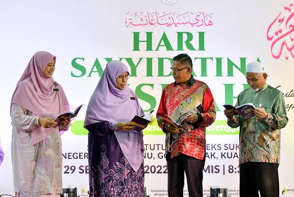 Siti Zailah (dua dari kiri) melihat buku dasar wanita pada Program Hari Sayyidatina Aishah 2022 dan Majlis Pelancaran Dasar Wanita Terengganu di Stadium Tertutup Kompleks Sukan Negeri pada Khamis. - Foto Bernama