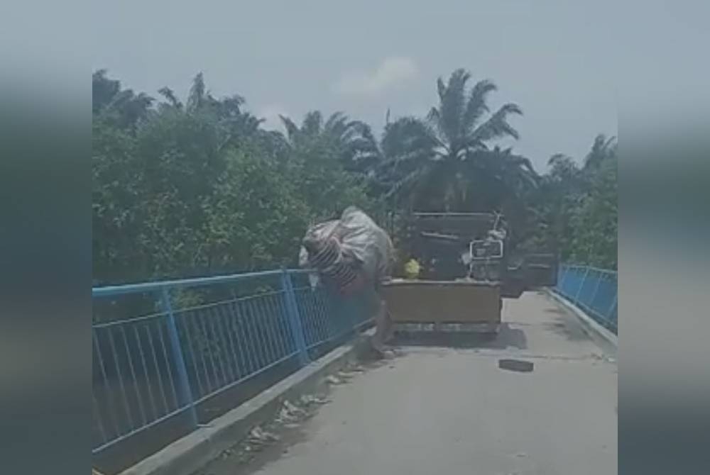 Tangkap layar video tular seorang lelaki membuang sampah di Sungai Wak Rabun Pontian