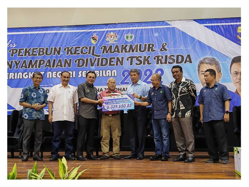 Mohd Salim (tiga dari kiri) dan Mohamad (empat dari kanan) menyerahkan mock-cheque kepada wakil penerima Dividen TSK Negeri Sembilan.