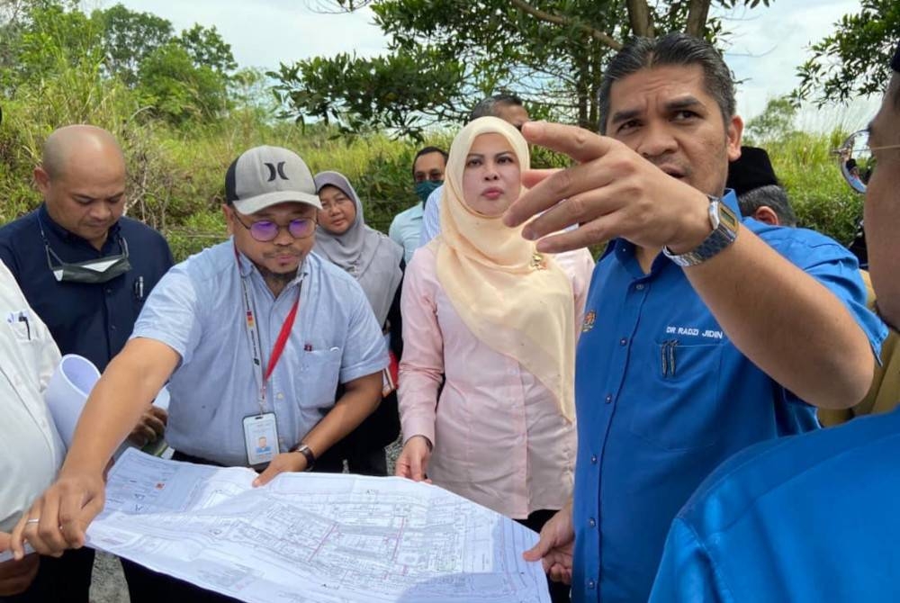 Mohd Radzi membuat tinjauan di tapak projek SMK Kota Warisan, dekat sini pada Jumaat. Turut hadir, Menteri Pembangunan Wanita Keluarga dan Masyarakat, Datuk Seri Rina Harun.