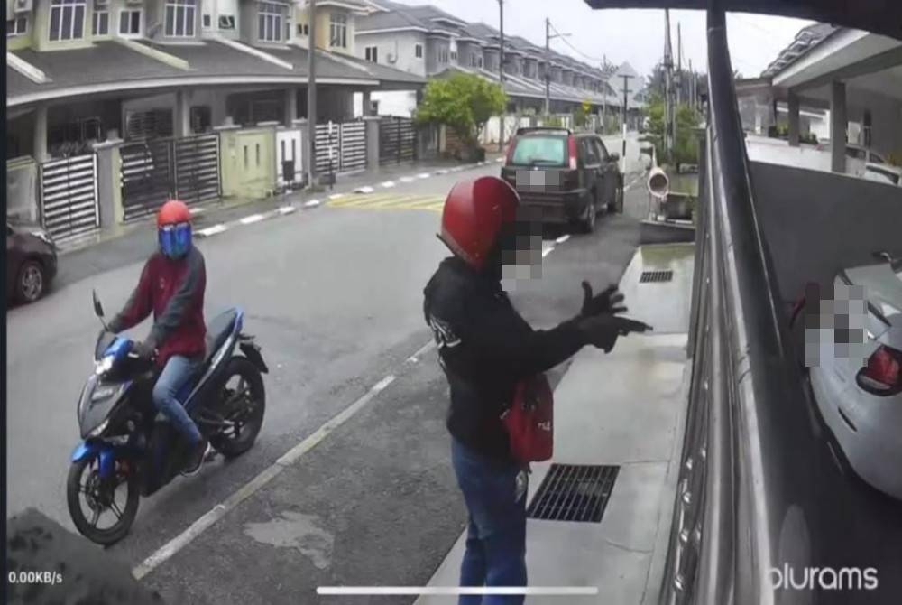 Tangkap layar CCTV mengesan seorang lelaki memegang senjata dipercayai pistol dalam kejadian di Sitiawan pada Jumaat. - Foto Ihsan pembaca