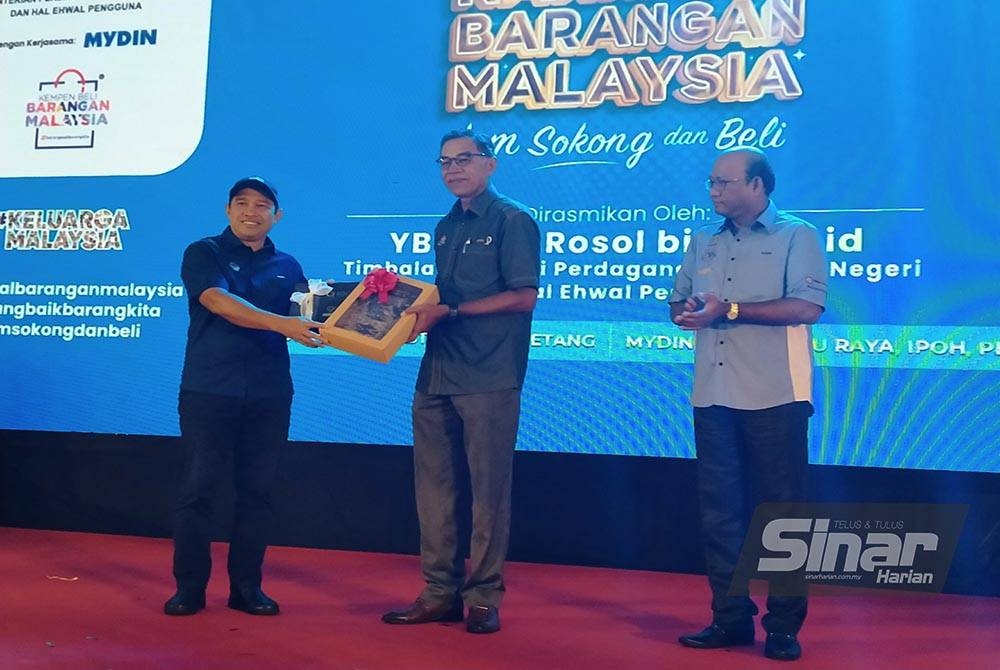 Rosol (tengah) menerima cenderahati daripada Abdul Yunus selepas menyempurnakan Perasmian Karnival Barangan Malaysia 2022 di pekarangan Mydin Mall Meru Raya pada Sabtu.