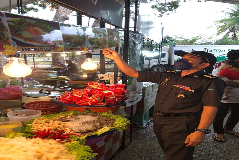 Penguatkuasa KPDNHEP sedang melakukan pemeriksaan terhadap gerai yang beroperasi di tapak jualan berkenaan pada Ahad. - Foto KPDNHEP