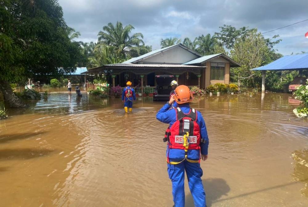 Anggota Angkatan Pertahanan Awam Malaysia melakukan pemantauan banjir di sekitar Kampung Sri Gambut, Pekan Nanas, Pontian.