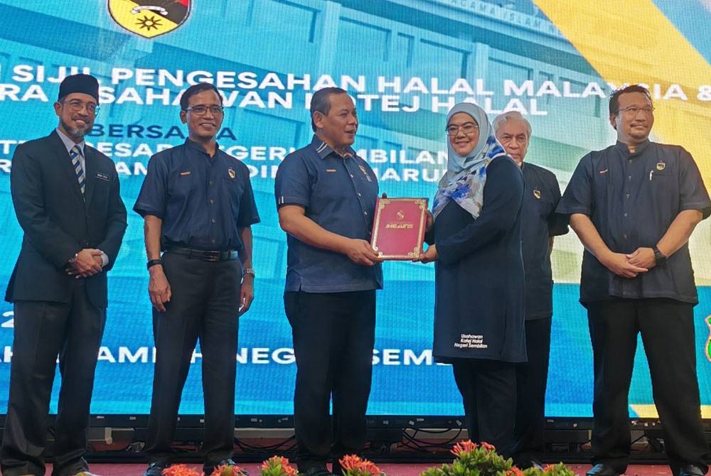 Aminuddin (tiga dari kiri) menyerahkan sijil pengesahan halal Malaysia kepada ushawan.