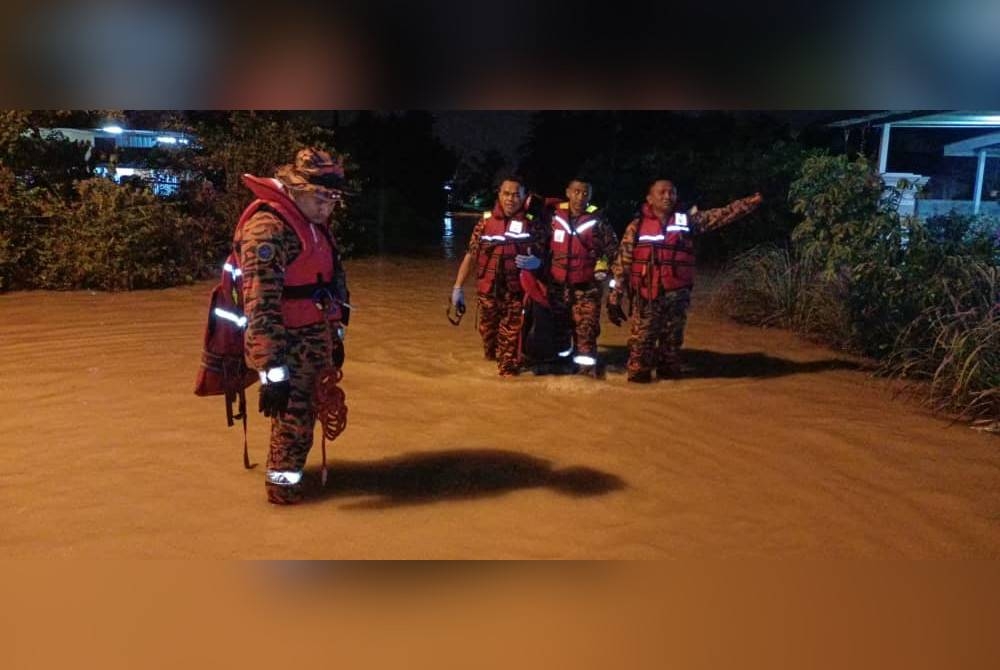 Anggota Bomba dan Penyelamat sedang membuat pemantauan serta membantu memindahkan mangsa banjir di RPT Chepor di sini pada malam Selasa. Foto: Bomba Perak