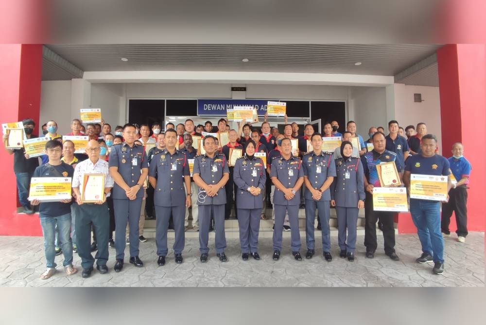 Sayani (tengah) bergambar bersama kesemua wakil Pasukan Bomba Sukarela pada Majlis Penyerahan Geran Bantuan PBS serta Sijil Penarafan Bintang di Dewan Mohamad Adib Ibu Pejabat JBPM Kedah, Jalan Suka Menanti, di Alor Setar, pada Rabu.