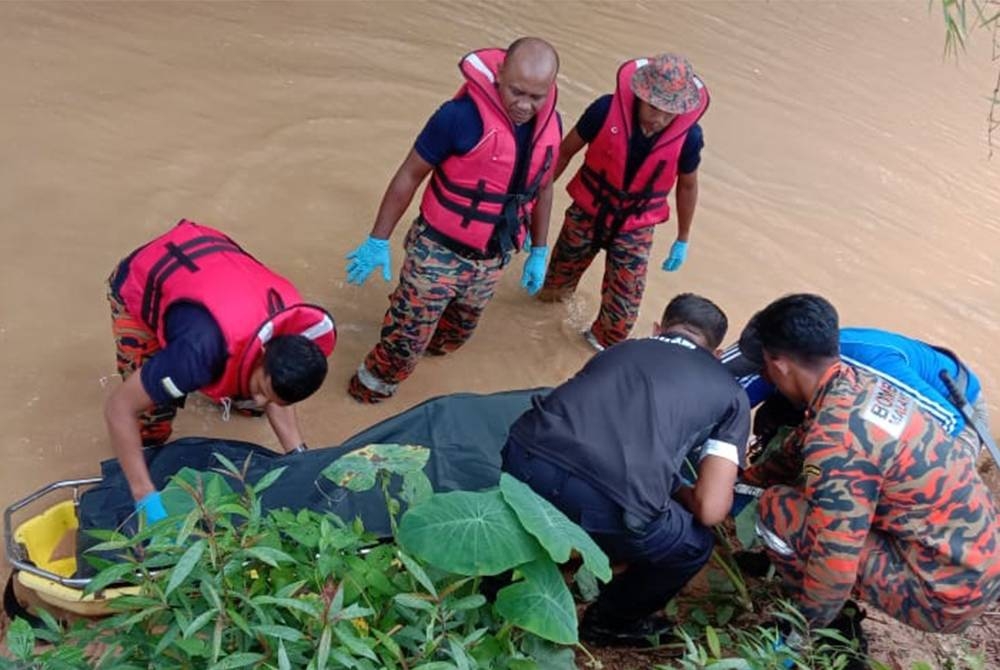 Pasukan Bomba dan Penyelamat Gerik membantu mengangkat mayat mangsa sebelum diserahkan kepada pihak polis untuk tindakan lanjut. - Foto bomba Perak