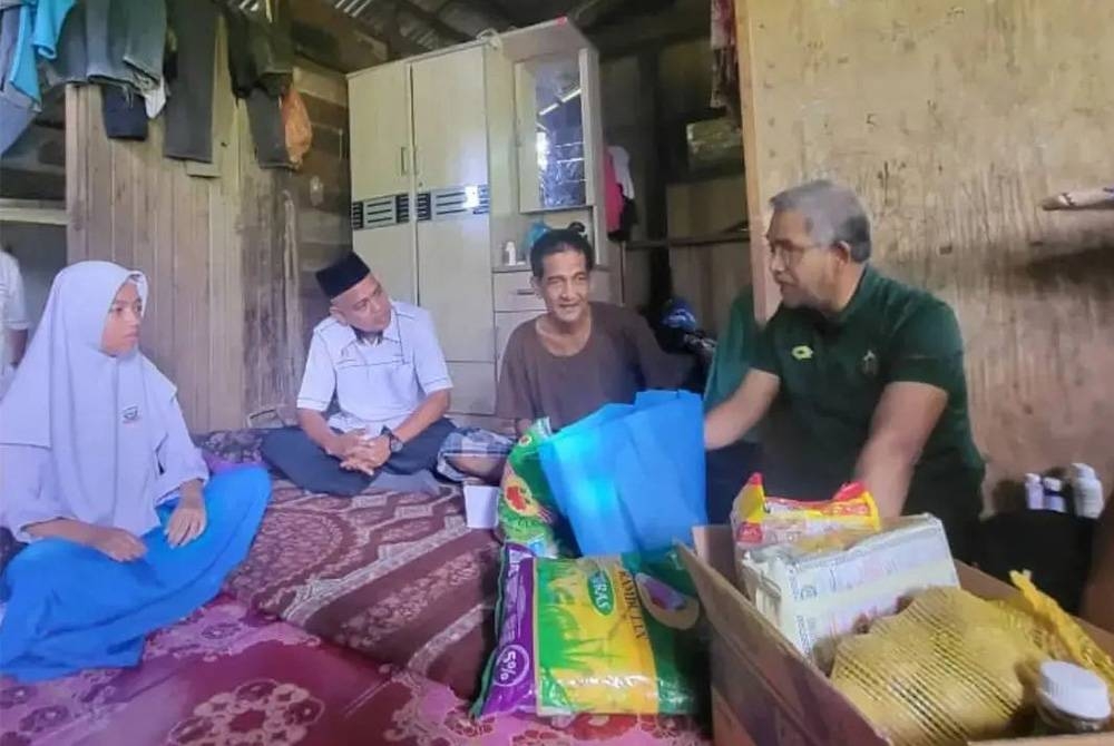 Mohd Daud (kanan) melawat keluarga Nurhanis bersama pengurusan SMK Sik baru-baru ini. - Foto FB Mohd Daud Bakar