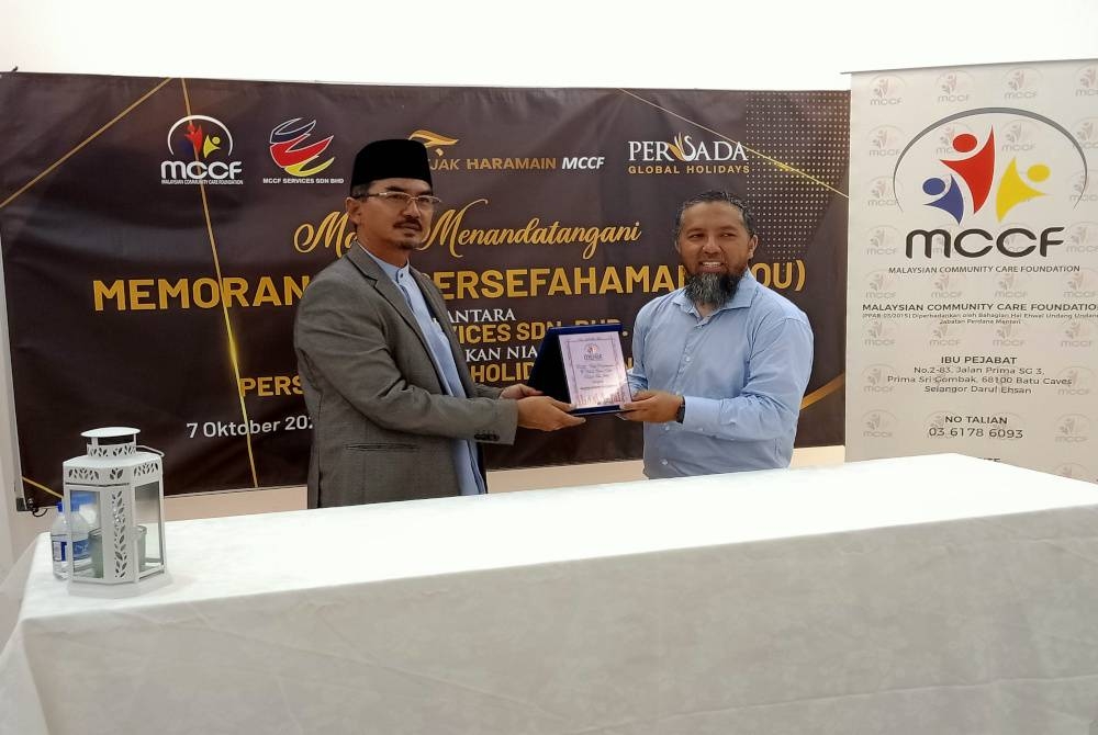 Halim (kiri) dan Pengarah Urusan Persada Global Holidays, Mohd Hafizi Abdul Fatah ketika Majlis Menandatangi Program Jejak Haramain MCCF dengan kerjasama Persada Global Holidays di Setia Alam pada Jumaat.