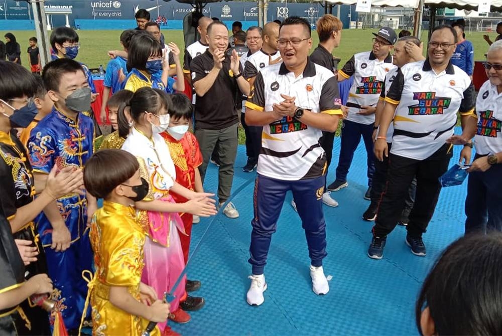 Mohd Hairi (tengah) bersama atlet wushu cilik pada Hari Sukan Negara peringkat negeri Johor 2022 di Dataran Bandaraya Johor Bahru pada Sabtu.