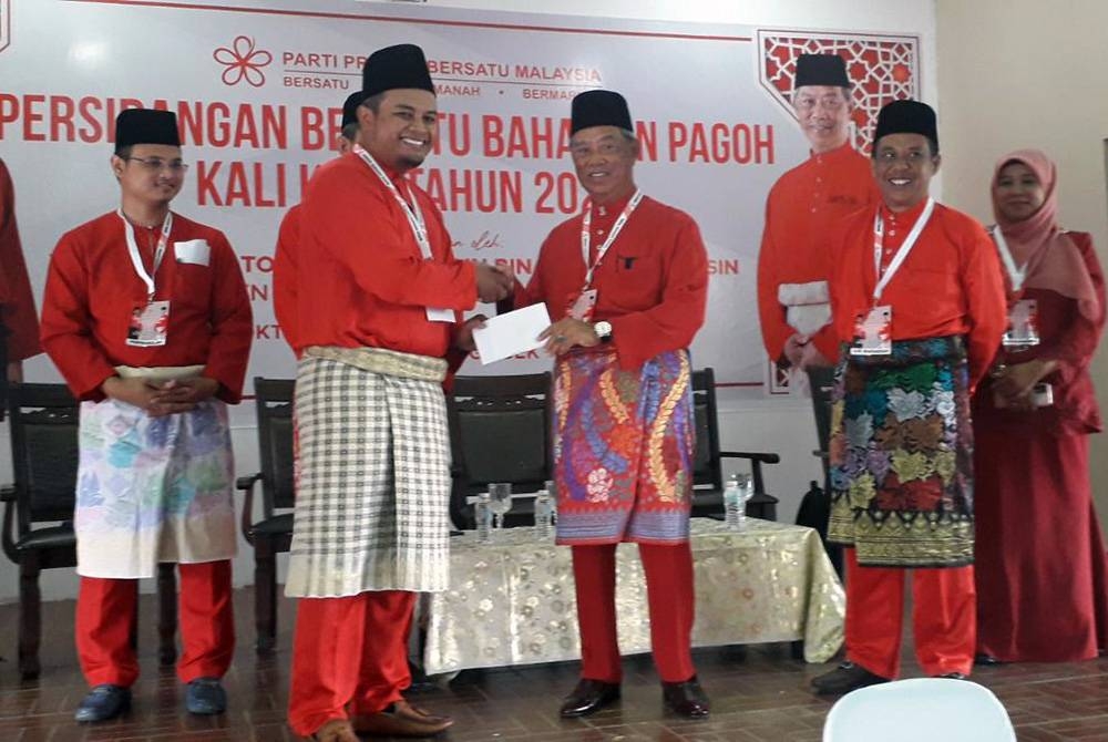 Muhyiddin (tiga dari kanan) menyerahkan sumbangan untuk pembukaan Pusat Daerah Mengundi (PDM) pada Persidangan Bersatu Bahagian Pagoh di Tangkak, pada Sabtu.