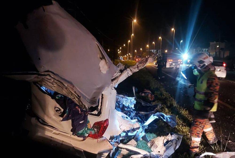 Kereta yang dipandu mangsa remuk selepas bertembung dengan sebuah lori tangki di Segari. - Foto Bomba Perak