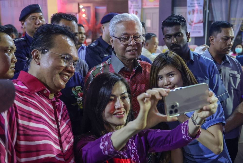 Pengunjung tidak melepaskan peluang berswafoto bersama Perdana Menteri pada Majlis Jamuan Makan Malam Keluarga Malaysia di Dataran Aurora Walk pada Sabtu. - Foto Bernama