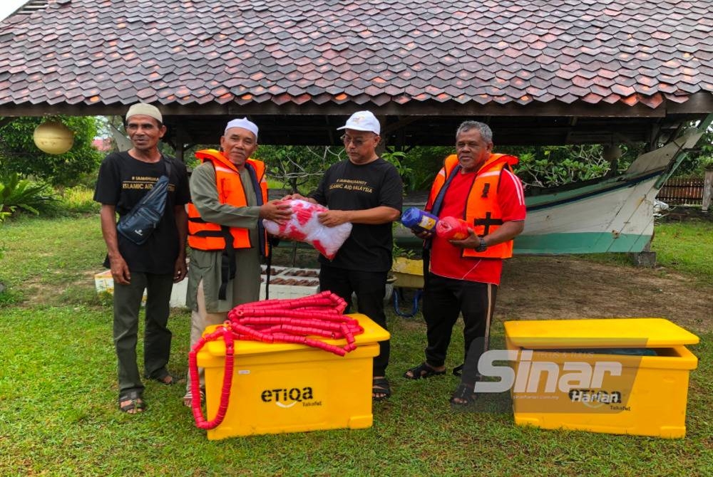 Zawahir (dua dari kanan) menyampaikan sumbangan pukat kepada salah seorang penerima, Mohamad Razali Hamad di Bachok. - Foto Sinar Harian