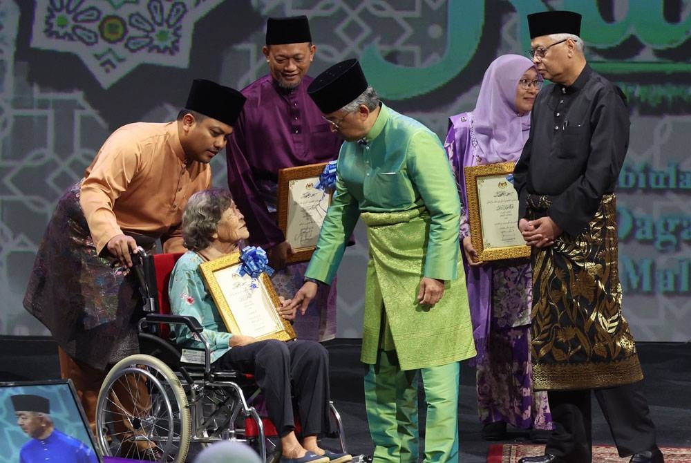 Yang di-Pertuan Agong berkenan beramah mesra bersama Anugerah Ikon Ibu Sejati Keluarga Malaysia Chee Hoi Lan (berkerusi roda). -Foto Bernama