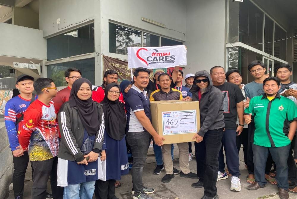 Saiful (depan tiga dari kanan) bersama kotak pakaian musim sejuk yang berjaya dikumpulkan di bawah projek &#039;Warm Their Winter’ pada Ahad.