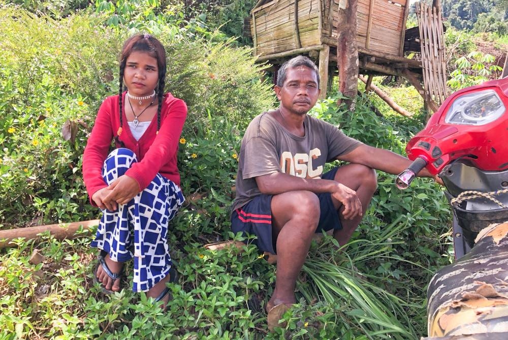 Mirsudiar bersama Along ketika ditemui pemberita di hadapan rumah mereka di Kampung Gawin, dekat Pos Gob, Gua Musang. - Foto Bernama